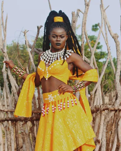 Wiyaala posing gracefully in a vibrant farm setting, showcasing her connection to nature and her cultural roots