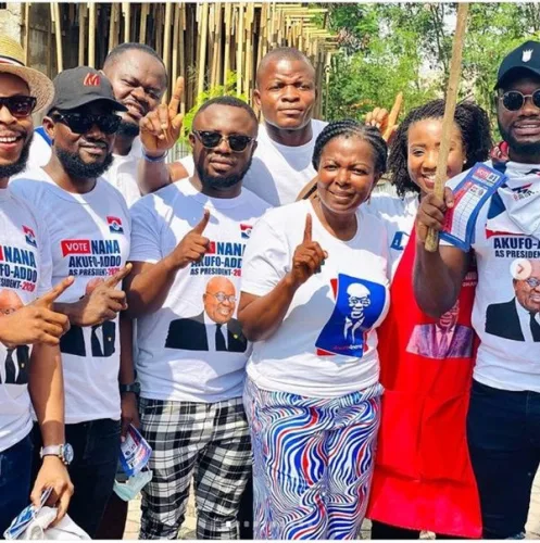  NPP Parliamentary candidate stands proudly with various celebrities who have endorsed the NPP party, showcasing a united front of public figures supporting the political movement. The group smiles together, highlighting the intersection of entertainment and politics in Ghana.