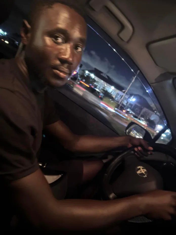 Incredible Honesty: Bolt driver Albert Quansah smiling and sitting behind the steering wheel of his car, looking directly at the camera.